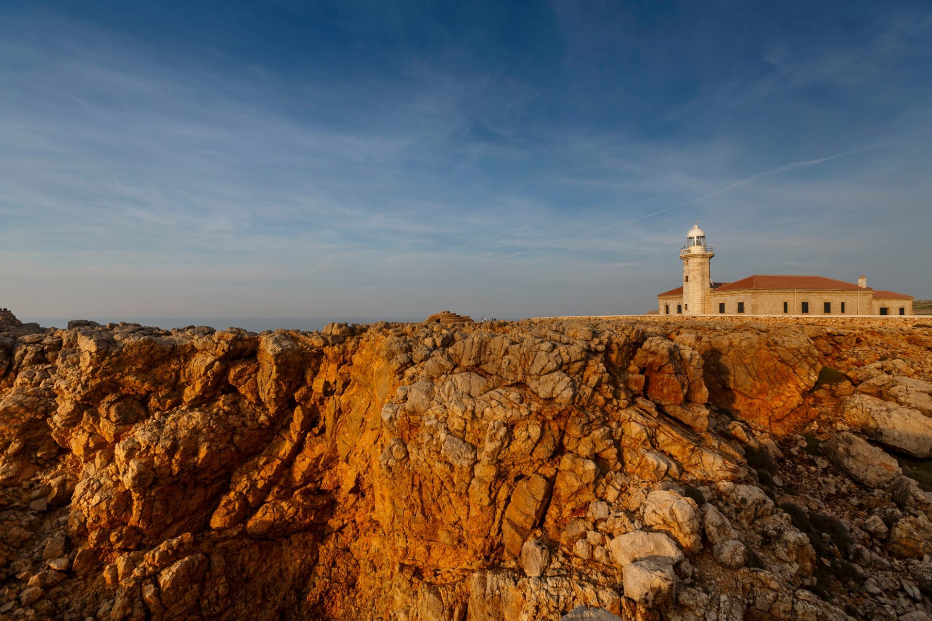 Inicio View of Punta Nati lighthouse on sunlit cliff, Menorca, Spain